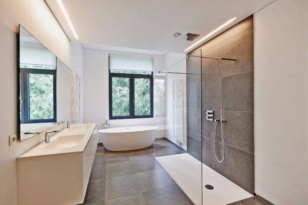 Luxury modern bathroom Bathtub in corian, Faucet and shower in tiled bathroom with windows towards garden